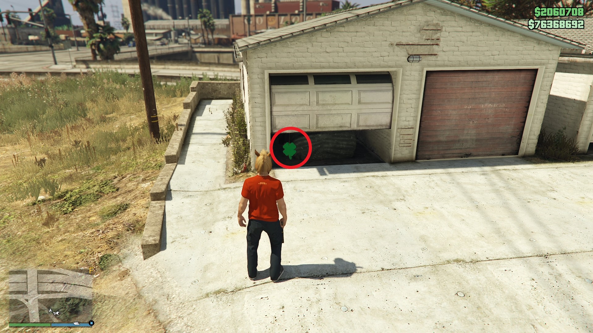 The lucky clover is hanging just inside a half-open garage door of a residential house in El Burro Heights.