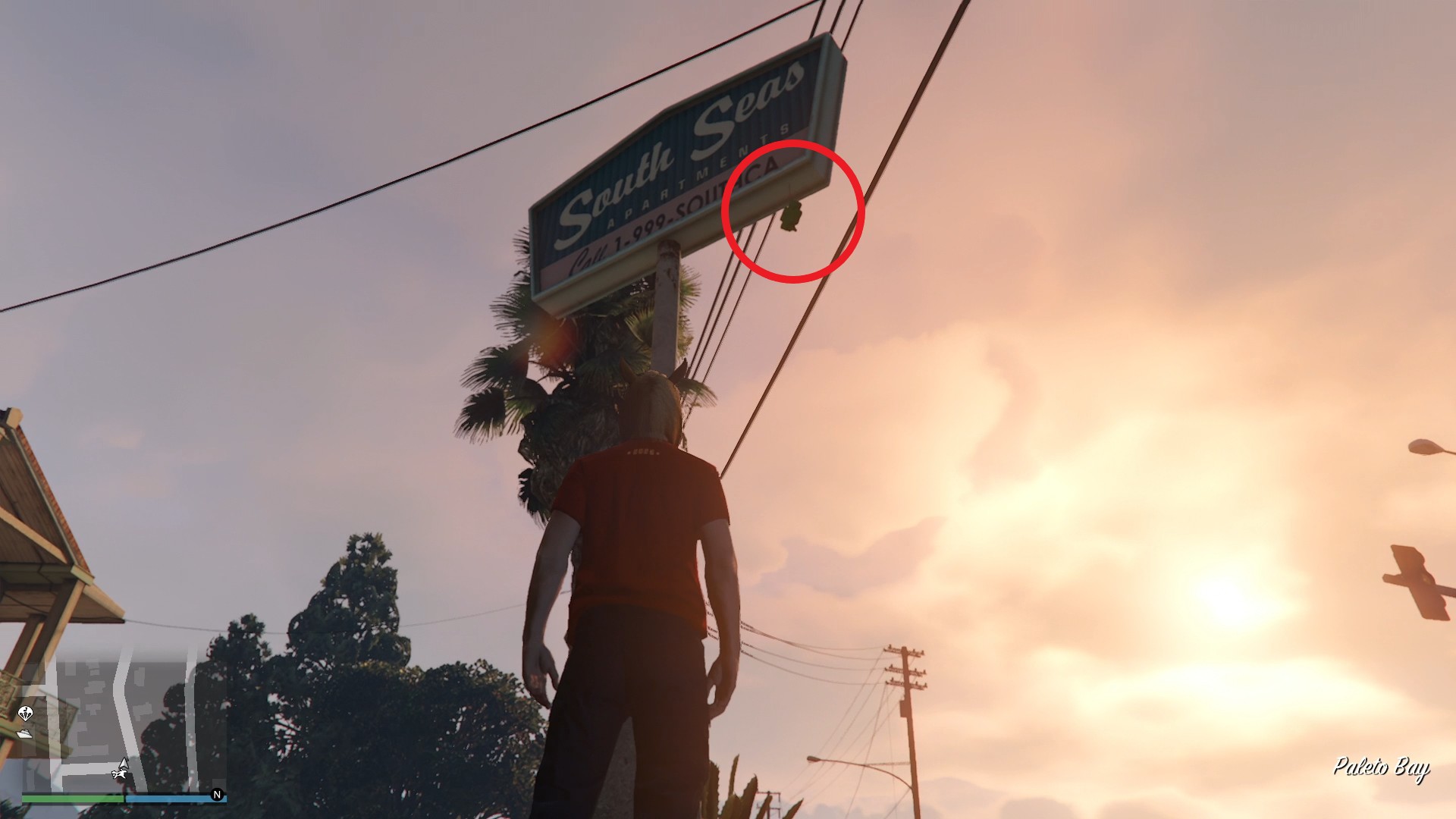 The lucky clover is hanging by the South Seas Apartments sign.