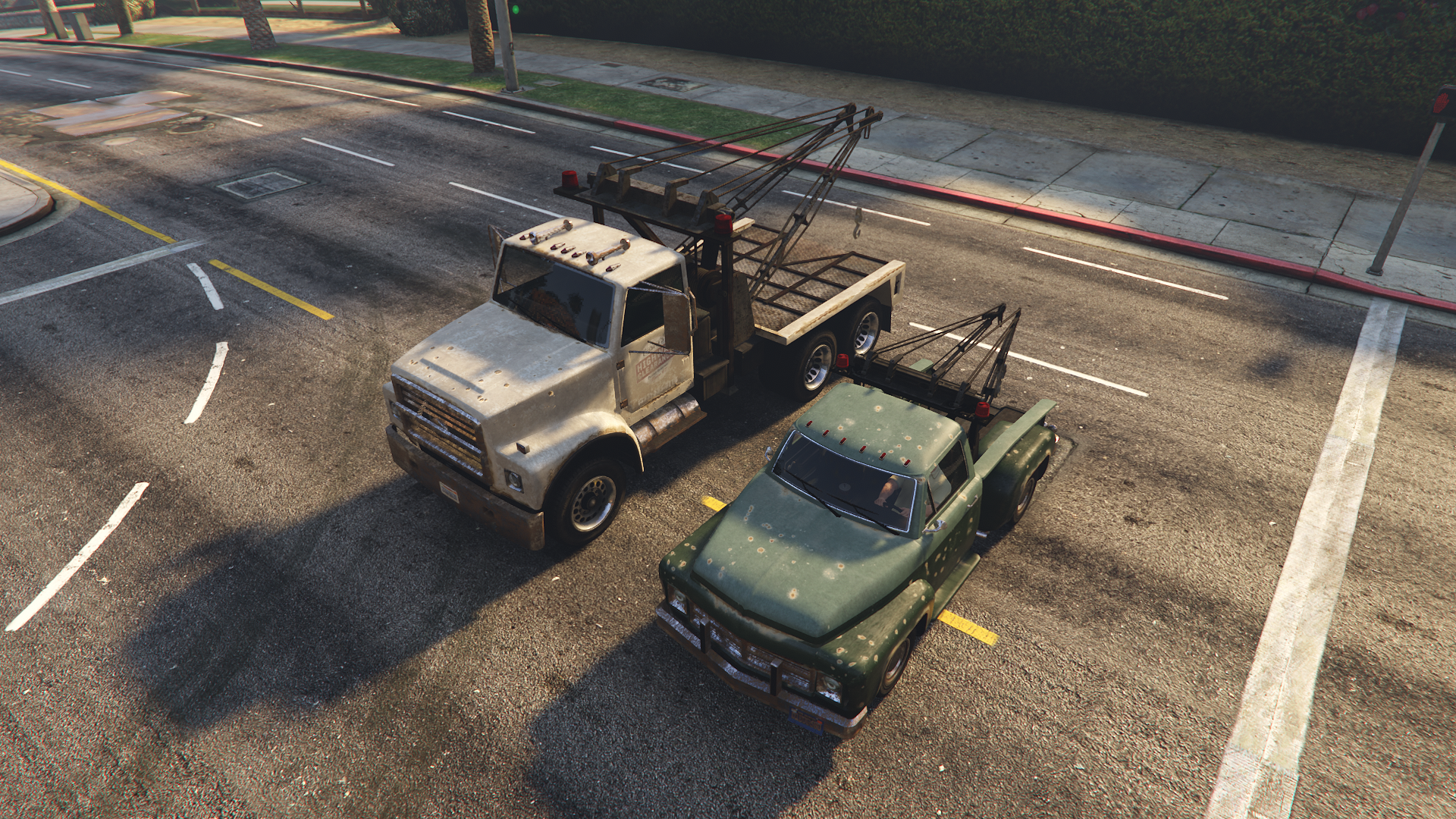 Vapid Tow Truck next to a larger variant of a tow truck seen in GTA Online.