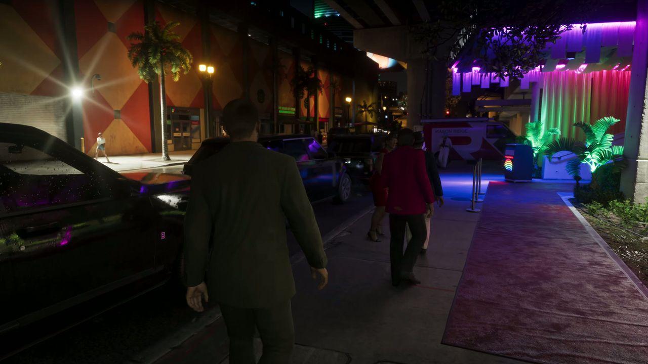 Guests arrive outside a club glowing with pink, green and blue light.