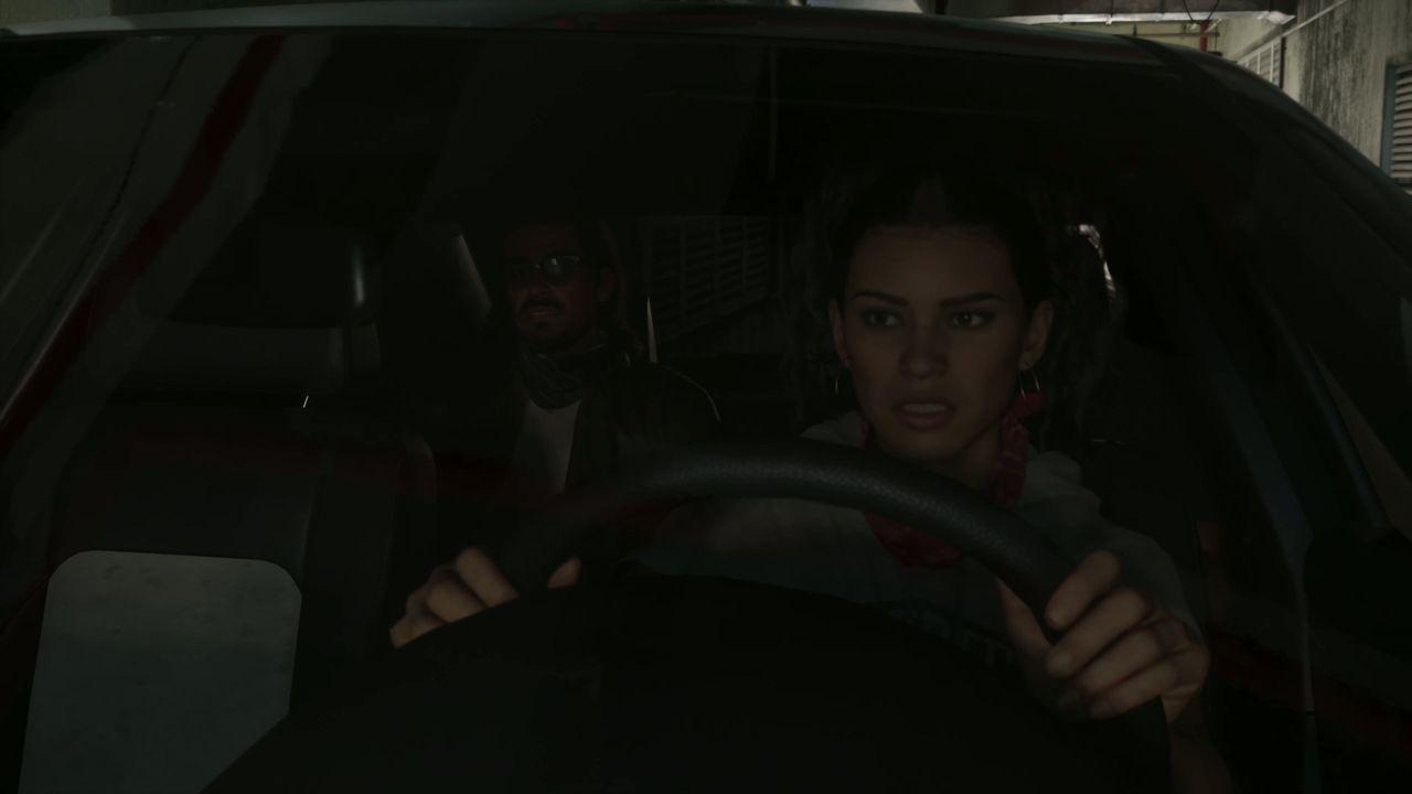 Lucia takes the wheel while a masked passenger sits behind her.