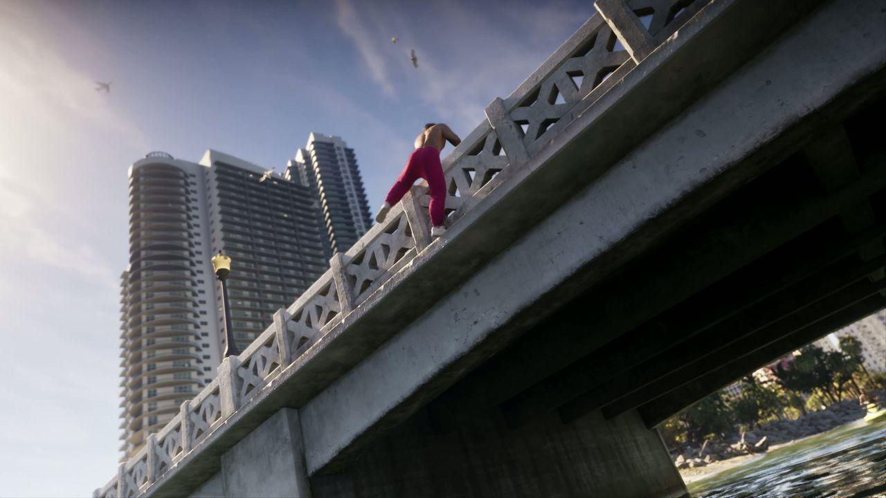 A climber scales the side of a bridge above the road.