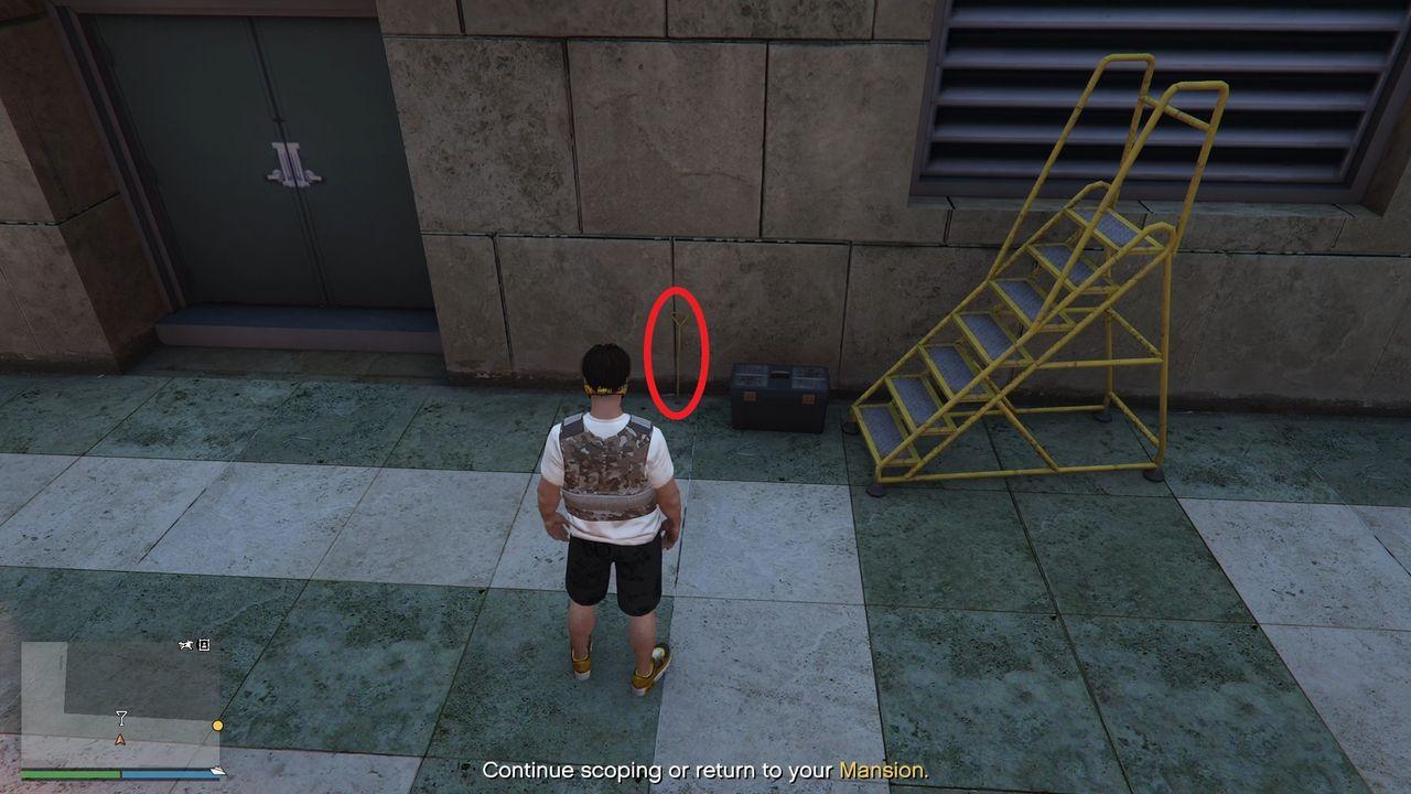 The manhole key is on the floor leaning against the wall.