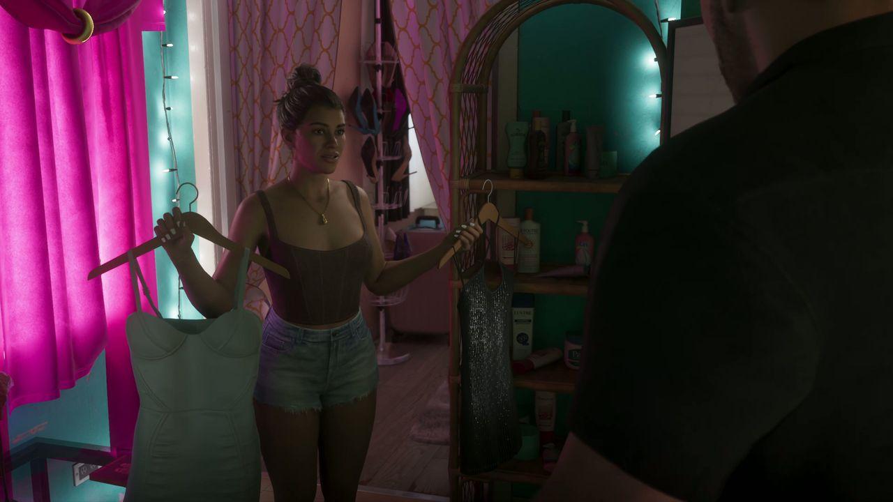 A woman compares two dresses inside a bright pink bedroom.