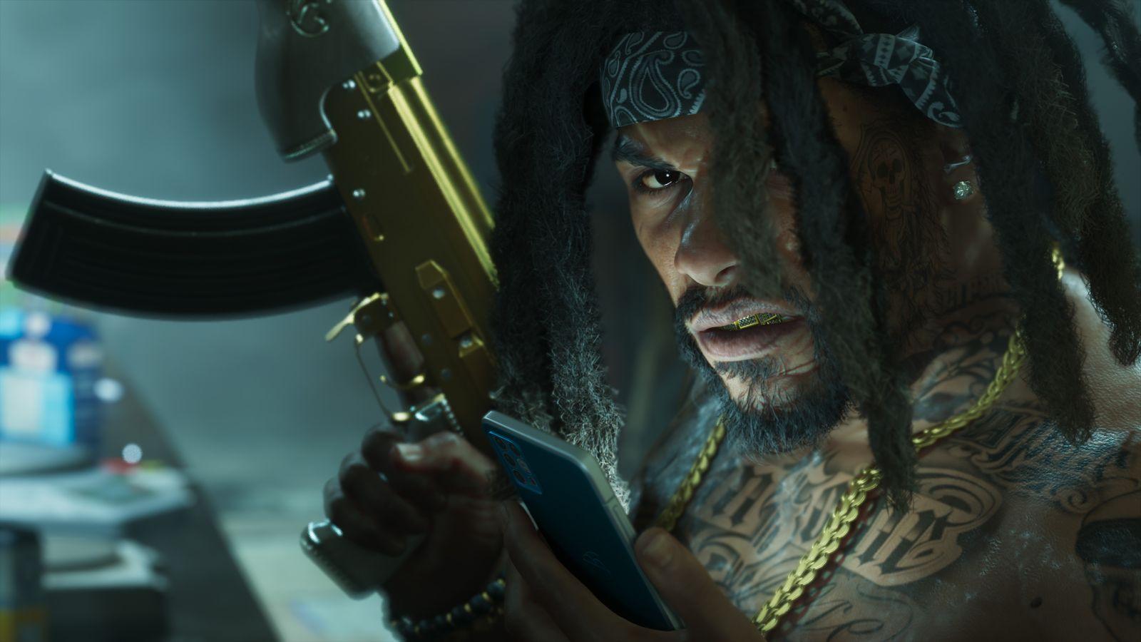 A heavily tattooed man checks his phone while holding a gold-finished rifle.