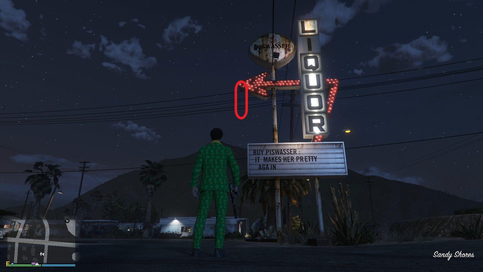 The golden clover will be hanging off the tip of the arrow on the Liquor store sign in Sandy Shores.