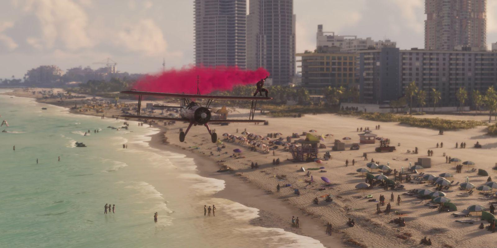 A person stands on a biplane’s upper wing, trailing pink smoke above a busy beach.