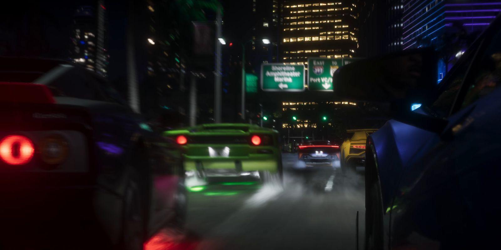 Sports cars crowd a city road beneath illuminated high-rises.