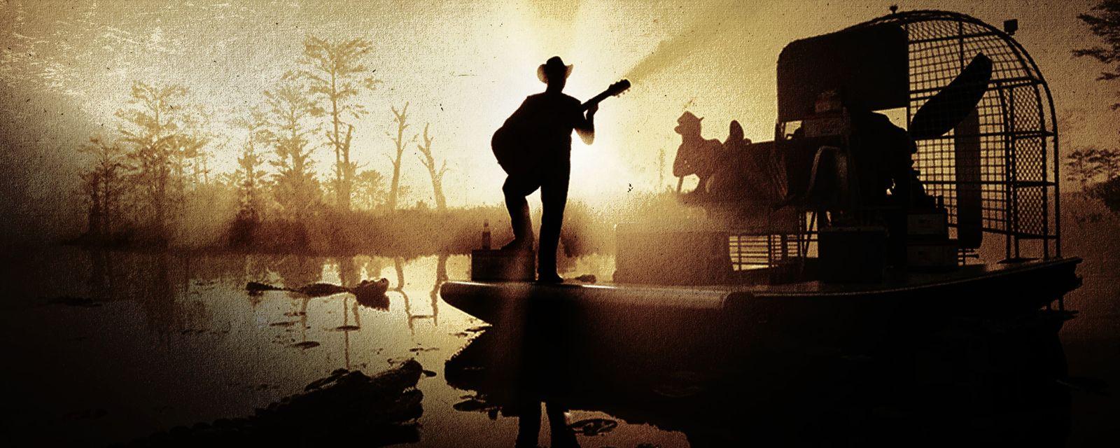 A guitarist stands on an airboat in Back Country Radio’s swamp artwork.