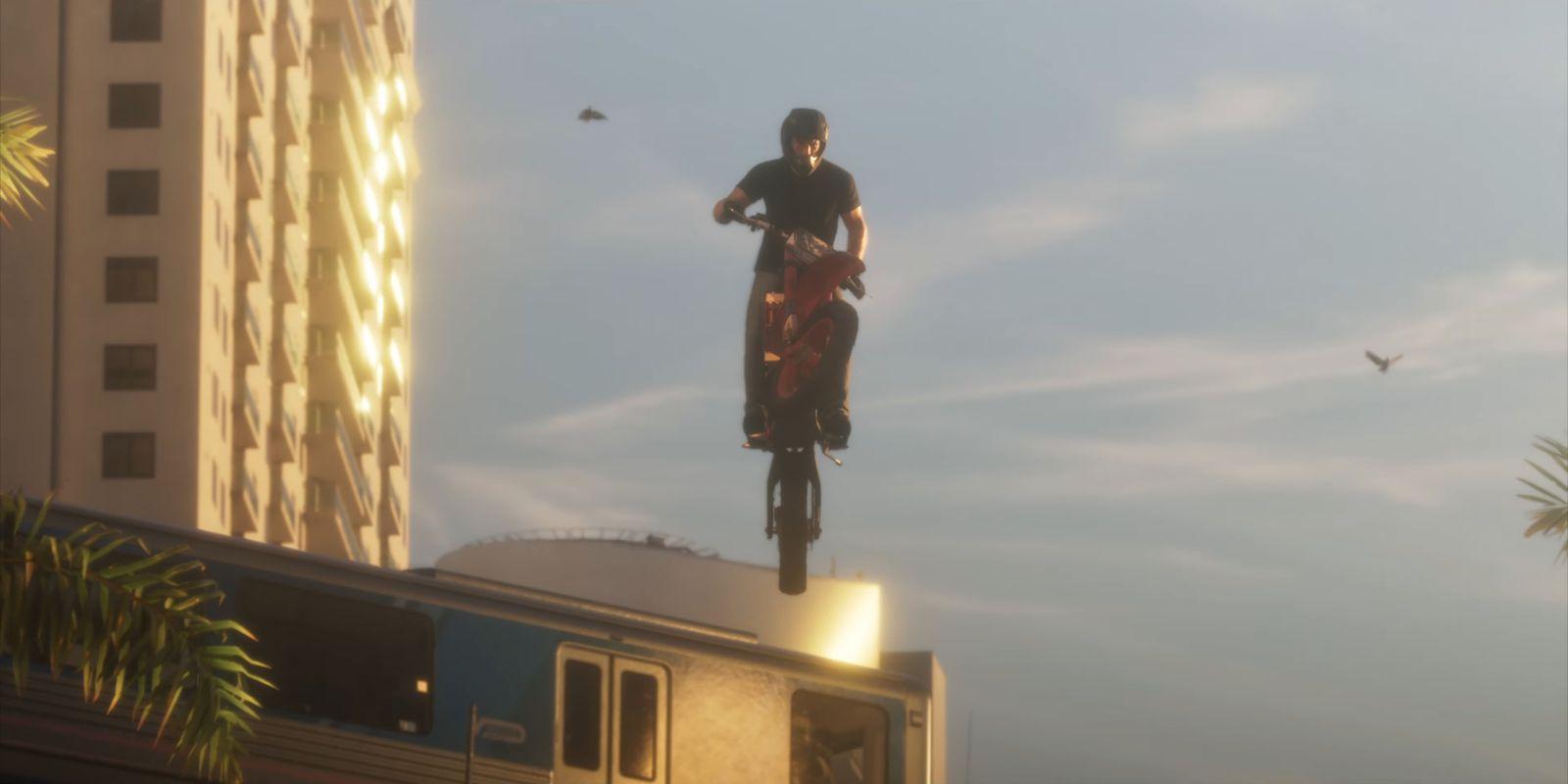 A motorcyclist is airborne above an elevated train.