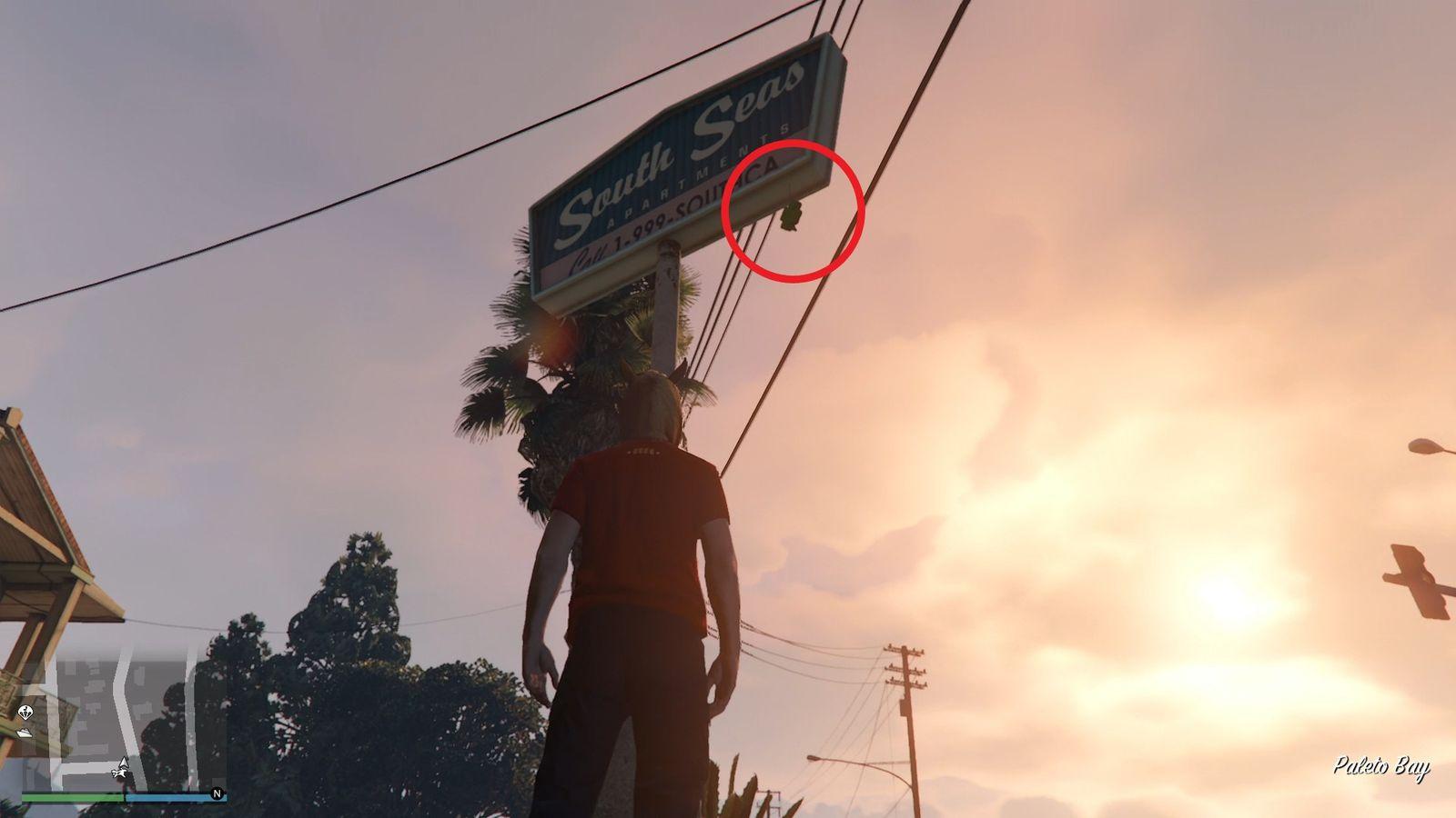 The lucky clover is hanging by the South Seas Apartments sign.
