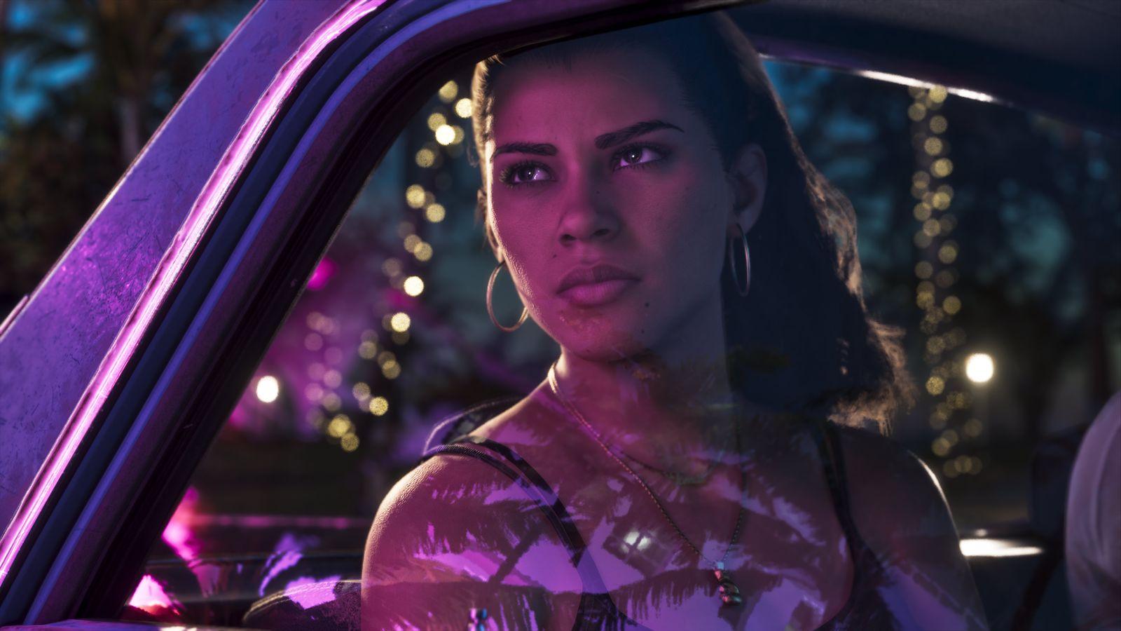 Lucia sits in a car under pink and blue neon light.