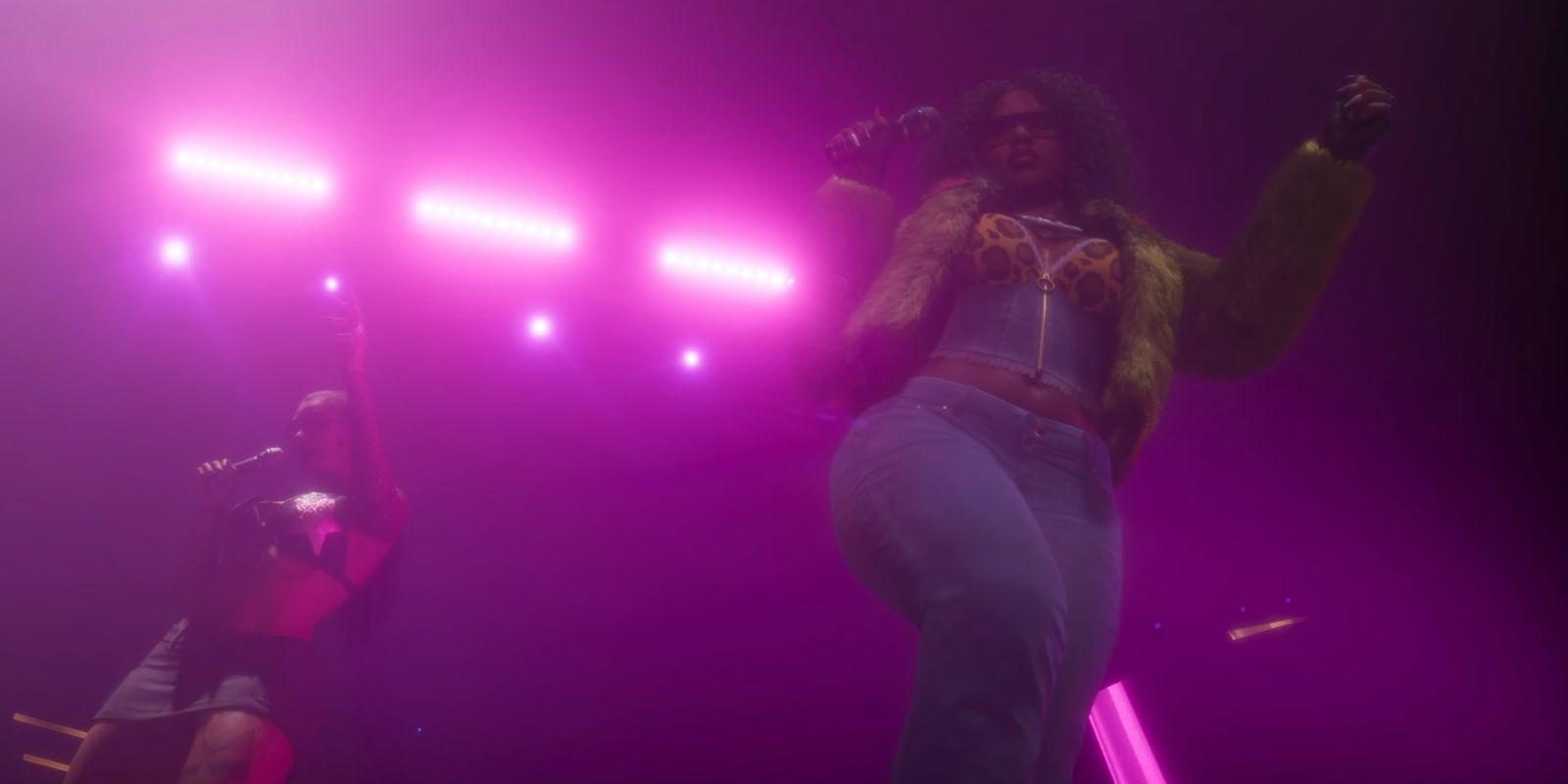 Two performers hold microphones beneath bright pink stage lights.