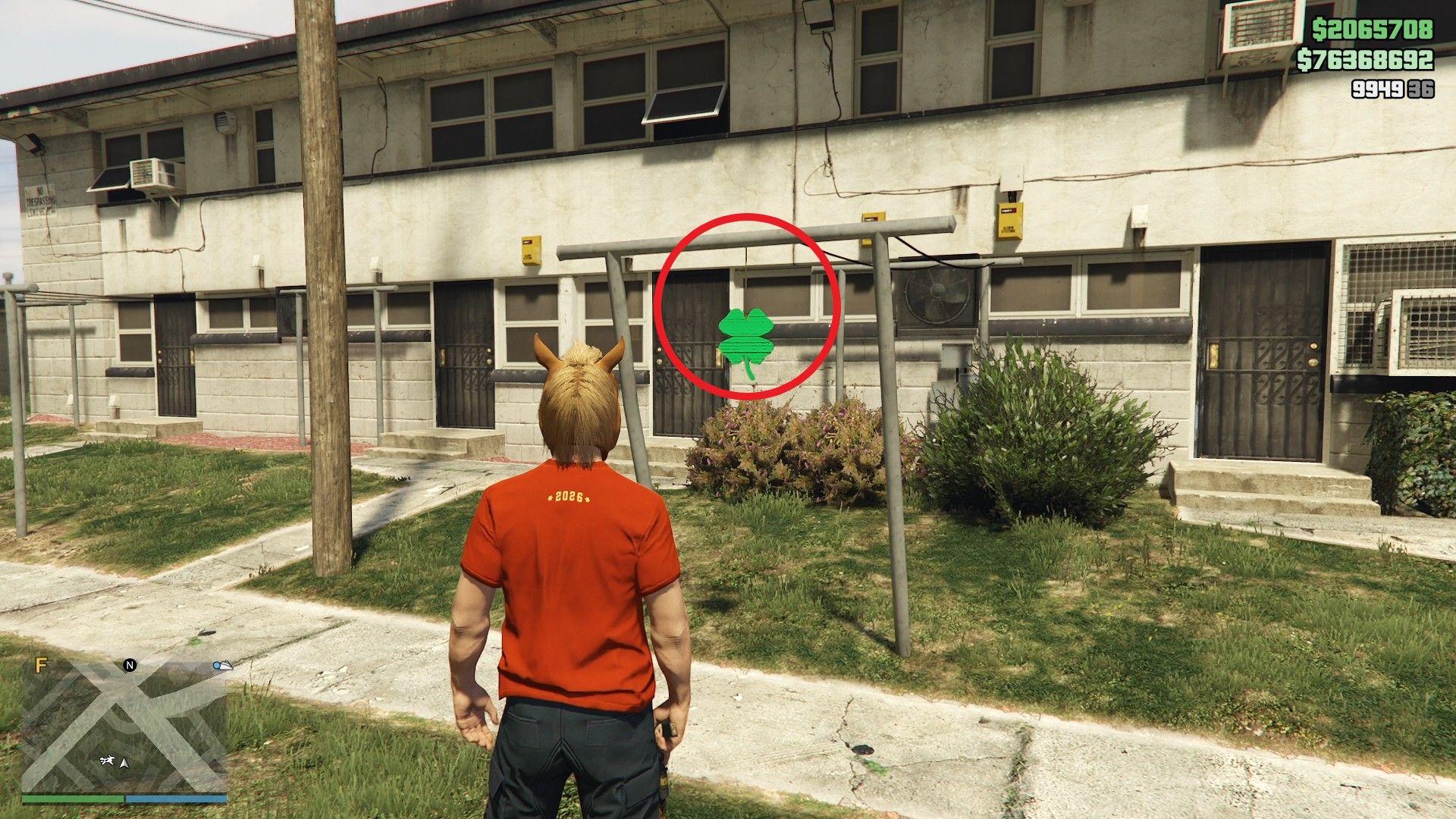 The lucky clover is hanging off a metal drying rack in the front yard of a run-down apartment complex in Rancho.