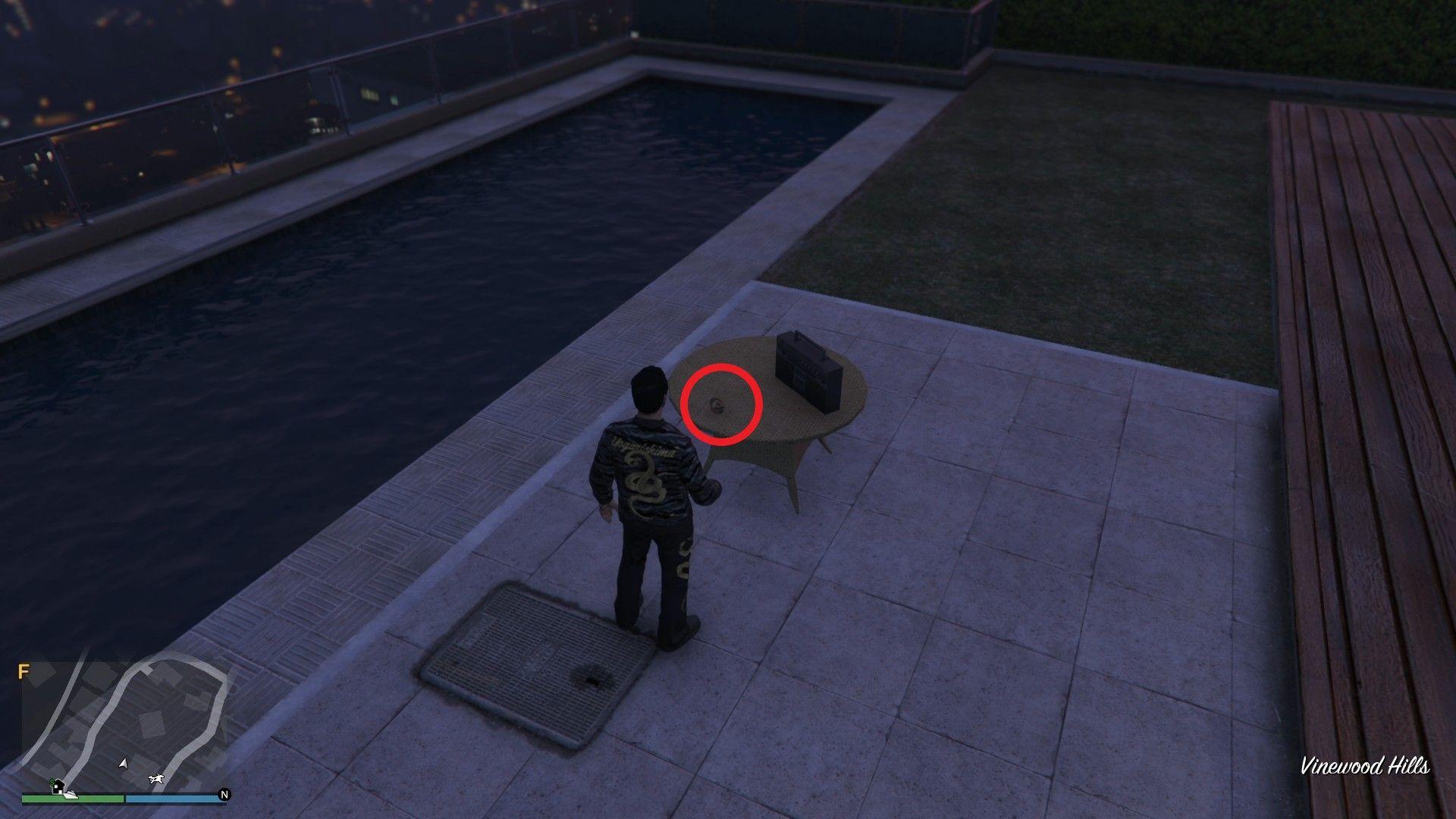 The Yuanbao is on the table by the swimming pool in the backyard of the house.