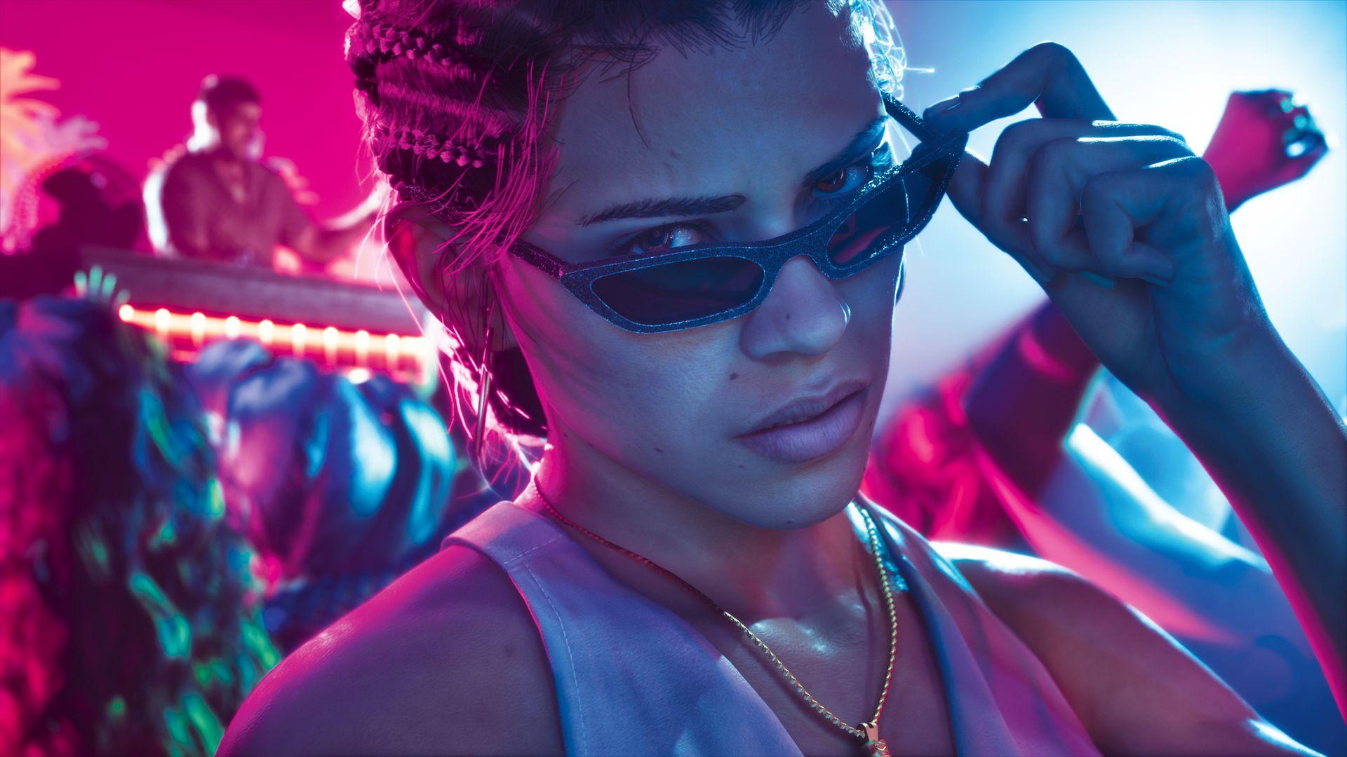 Lucia looks over sunglasses under pink and blue club lighting.