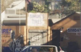 Simon's Tires uses hand-painted signs around a shallow corner workshop.
