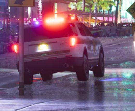 Rear three-quarter view of a white police SUV with illuminated emergency lights.