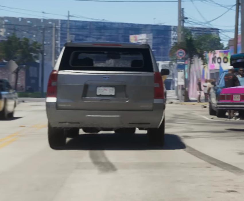 Silver SUV seen from behind, with a handle above its rear number plate and pale sections within its taillights.